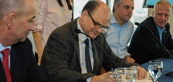 Andrés Tolosa firma acuerdo en nombre de Antel. Imagen: Antel.